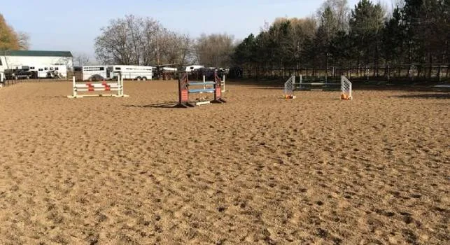 Outdoor sand arena with jumps set up